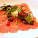 Carpaccio di vitello con olive e pinoli