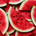 Composizione di fette di cocomero sovrapposte le une sulle altre: presentano una polpa succosa rossa, grandi ma pochi semi neri e buccia verde