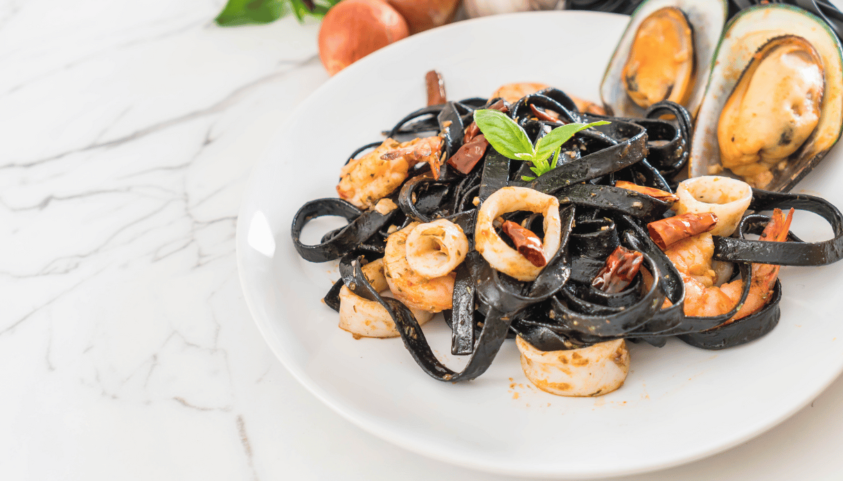 Penne al nero di seppia con calamari e pomodorini