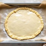 Pasta sfoglia stesa su teglia rivestita di carta forno.