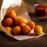 potato croquettes with red and white sauce on wooden table