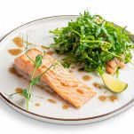 Steamed salmon with arugula and shrimps garnish