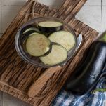 Tagliere con ciotola di melanzane crude a fette