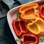 Peperoni crudi tagliati a metà nella pirofila