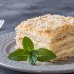 Layered cake with cream Napoleon millefeuille vanilla slice with mint on dark