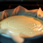 Foderate una tortiera con carta da forno e versatevi metà del composto