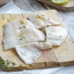 Tagliere con filetti di merluzzo crudi