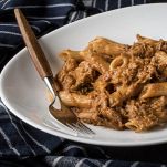 Penne al sugo di carne di manzo su sfondo scuro