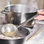 Uomo aggiunge liquidi alla carne in cottura