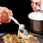 Male chef garnishing his dish, ready to serve