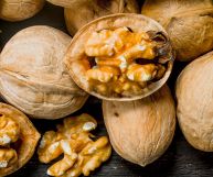 Vista dall’alto di noci comune: ce ne sono di chiuse, di aperte a metà e di sgusciate; i gherigli sono di un bel colore marrone chiaro tendente al senape