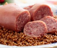 Due pezzi di zampone e due fette su lenticchie, classico piatto di Capodanno pronto per essere consumato; l’impasto dell’insaccato è umido