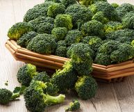 Sparacelli (broccoletti siciliani) color verde brillante adagiati su un vassoio di legno; le cime sono appena lavate e pronte per essere cucinate