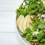 Spinaci, pere, noci e caprino in insalata