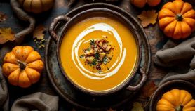 Ciotola con zuppa dorata guarnita con erbe fresche