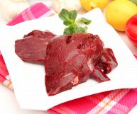 Piatto quadrato con fegato a pezzi su tovaglia quadrettata rossa e bianca; la carne è soda e compatta, la membrana lucida e il colore tendente al bordeaux