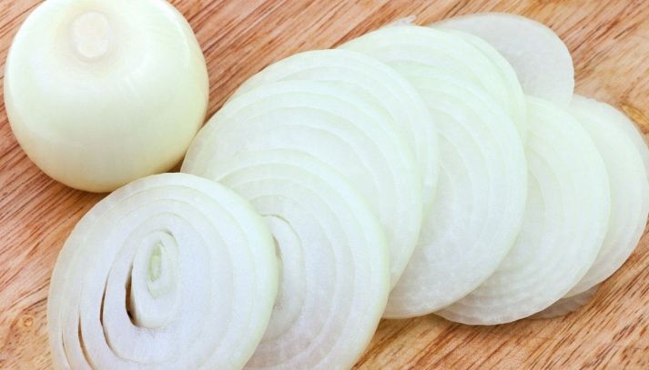 Cipolla bianca tagliate a fettine adagiate su un piano in legno e pronte per essere impiegate in gustose ricette