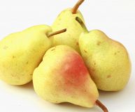 Quattro pere williams dalle medie dimensioni raggruppate in un piccolo mucchio; la pelle ha un colore paglierino tendente al rosso in alcune zone