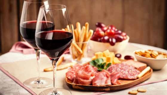 Tagliere con salumi e formaggio con calici di vino