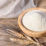 Whole wheat durum flour in wooden bowl on a wooden table
