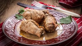 Involtini di vitello dorati in teglia e serviti su piatto con fondo di cottura.