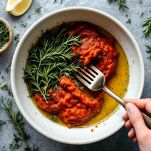 pomodoro con olio e rosmarino in una ciotola da mescolare