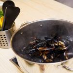 Pentola con cozze che si stanno aprendo