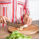 Donna taglia la banana sul tagliere