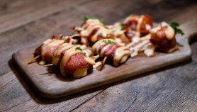 Involtini di pancetta e ananas cosparsi di salsa