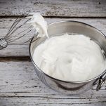 Whipped cream in bowl with and whisk