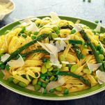Pasta tagliatelle with asparagus, peas, beans and parmesan cheese on top. healthy food