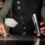Barman hands holding a shaker and a cocktail glass