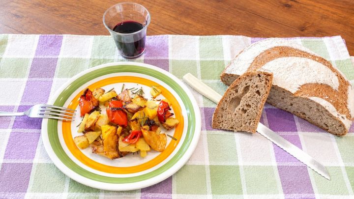 Patate e peperoni nel piatto con pane e vino