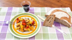 Patate e peperoni nel piatto con pane e vino