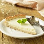 Slice of plain cheesecake on wooden table. Homemade desserts.