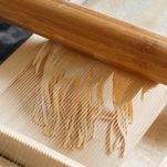 Making spaghetti alla chitarra with a tool – specialty of Abruzzo region
