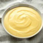 Bowl of vanilla custard on rustic background