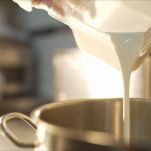 Ice-cream production. Mix ice cream. Pour the milk into a pan