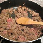 crumbled sausage cooking in a black pan