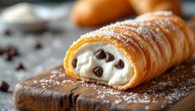 Cannoli ripieni e decorati su piatto da portata.