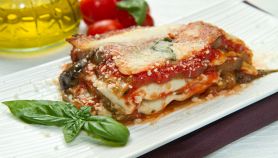 Parmigiana di melanzane impiattata con basilico fresco