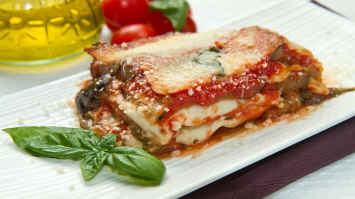 Parmigiana di melanzane impiattata con basilico fresco
