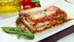 Parmigiana di melanzane impiattata con basilico fresco