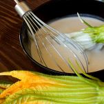 Passare i fiori di zucca dentro la pastella