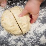 Tagliare con il coltello un pezzo di pasta in due