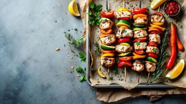Spiedini di pesce con verdure su insalata