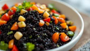 Riso nero con verdure colorate ben amalgamate nel piatto