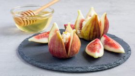 Fichi con quartirolo accanto a una ciotolina di miele
