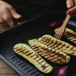 Donna griglia le zucchine