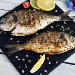 Una volta cotte togliete dal forno e trasferite il fondo di cottura in una padella, cuocete a fuoco alto per farlo ridurre e creare una crema densa. Servite le orate bagnandole con il fondo di cottura ottenuto, una fetta di limone fresco e le olive rimaste nella teglia.